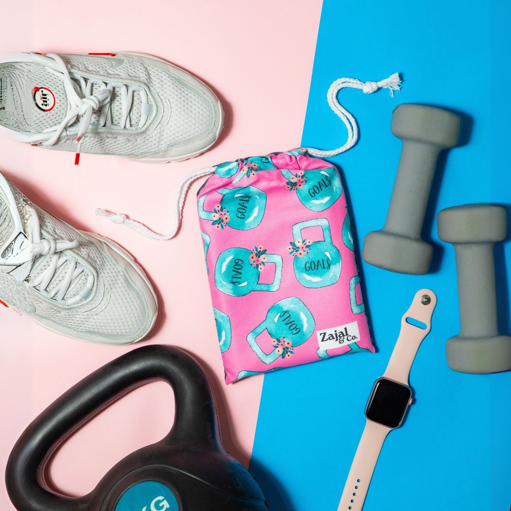 gym_gear_flatlay_with_pink_patterned_towel_and_weights